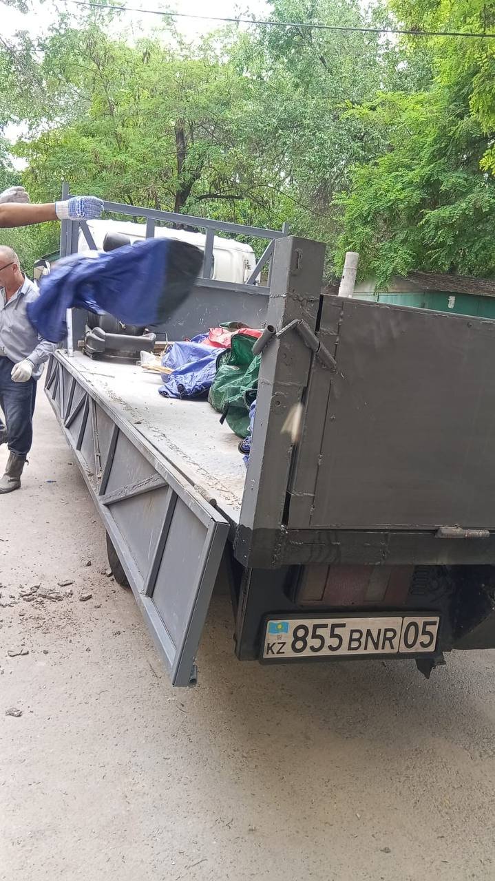 Рабочий загружает мешки с мусором в наш бортовой грузовик
