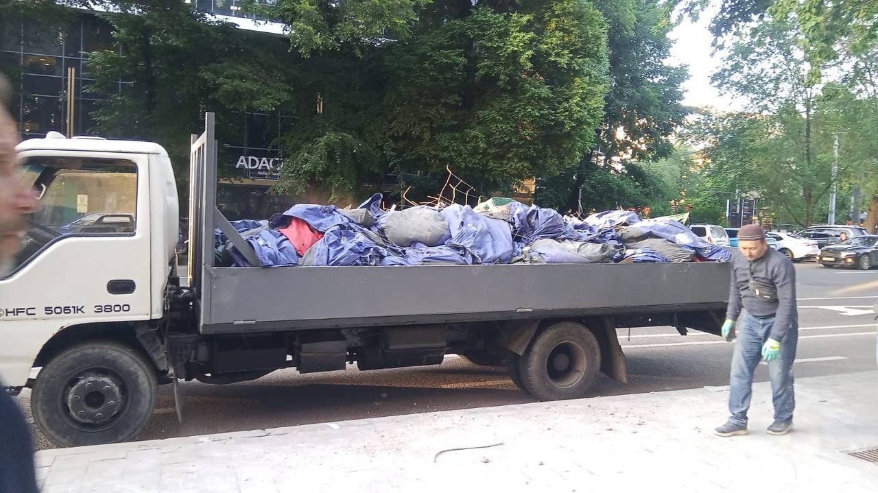 Бортовой грузовик с мешками строймусора — вывоз в городе
